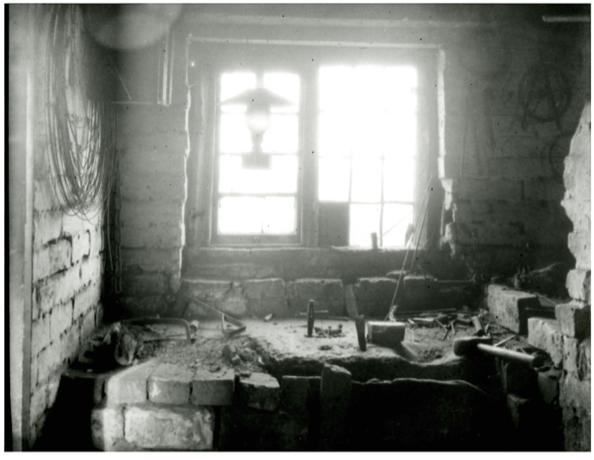 B+W image of the interioe of anAwl Blade maker's workshop Sandbank Bloxwich 1915. Tools, lamp stone block
